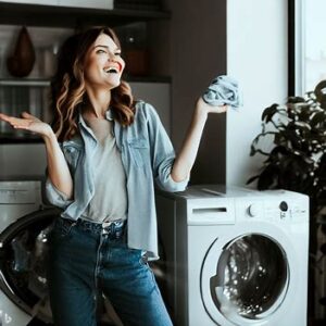 kobieta i pralka- naprawa suszarek i pralek Poznań i okolice